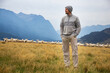 Man with merino wool sweater and hat in front of merino sheep
