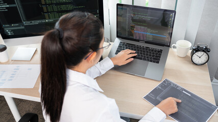 Asian Woman programmer typing source codes Programming On Computer in office, freelance web developer concept.