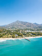 © alexemarcel - Unique aerial view of luxury and exclusive area in Marbella, golden mile beach, view of Puente Romano Bridge and in background famous La Concha mountain. Emerald water colour