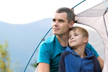 Wall Mural - Young dad and his child son hiking together in summer mountains. Active family travelling concept.