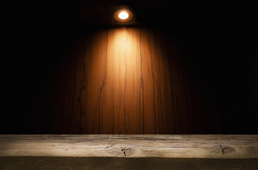 empty wooden table on which beams of light from lamps fall on a dark background, place for your products on the table