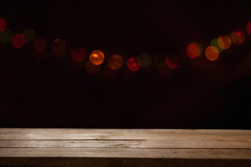 empty wooden table on blurred light gold bokeh of cafe restaurant on dark background, blurred cafe interior place for your products on the table