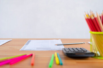 Paper and pens, pencils are ready to be used on the desk