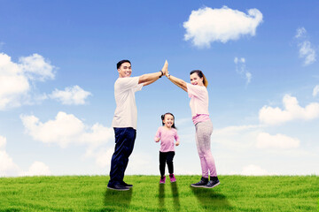 Sticker - Happy family making house symbol at meadow