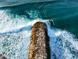 Aerial view from a stone jetty. Stone wave breaker blocks to protect the coast from erosion.