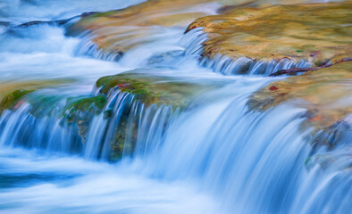 closeup small brook rushing over the stones, beautiful natural background