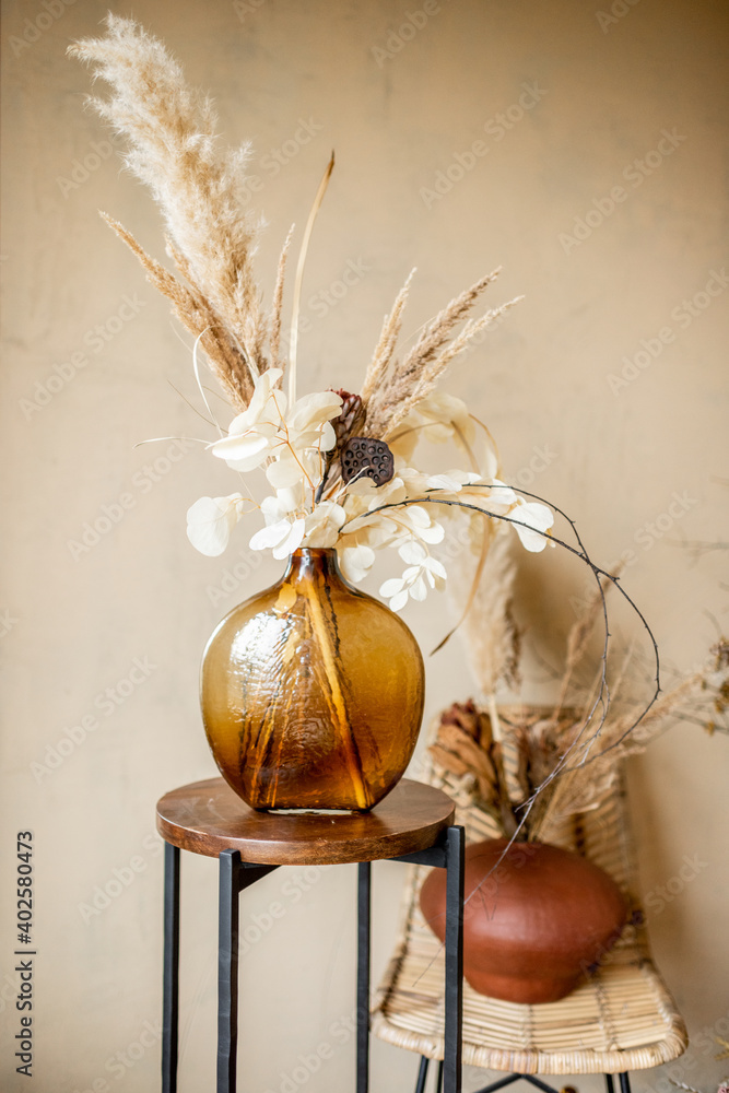 Composition of dried flowers and herbs in vases on a beige wall background - obrazy, fototapety, plakaty 