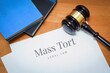 © MQ-Illustrations - Mass Tort. Document with label. Desk with books and judges gavel in a lawyer's office.
