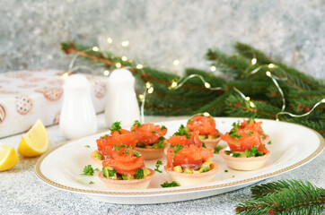 Avocado and salmon appetizer on the New Year's table. Tartlets with fish.