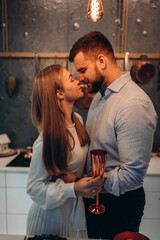 Wall Mural - The guy and the girl celebrate the New Year. A married couple retired in a cozy studio setting. Location in the kitchen.