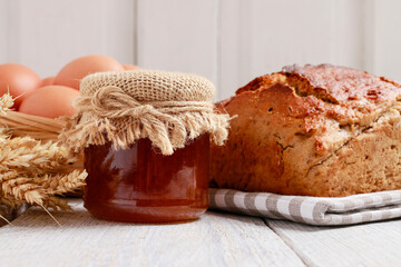 Sticker - Loaf of bread and basket of eggs on white wooden table.