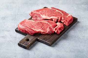 Wall Mural - Two Fresh Raw meat Prime Black Angus Beef Steaks, Rib Eye, Denver, on wooden cutting board