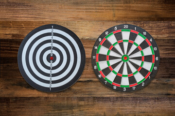 Two styles of dart boards Dartboard with darts on old wooden background concept, goals and achievements.