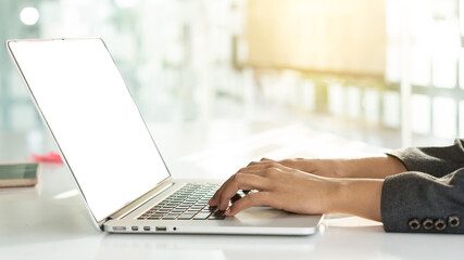 The hand of a business woman is typing a keyboard to work on a laptop