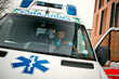 © Valerii Apetroaiei - An adult handsome male paramedic is talking on a portable radio while sitting in an ambulance outside a clinic.