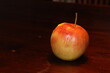 Single red and yellow apple on a dark table