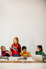 happy kids programming electric toys and robots at robotics classroom
