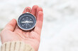 © hardvicore - Woman hand holding compass against light blurred background. Hiking traveler equipment. Navigation for travel. Find way and destination. West or east? Finding yourself. Сloseup shoot.