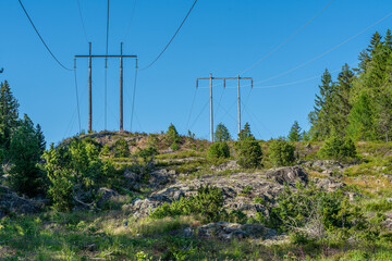 Power lines passing up a hill on the swedish countryside