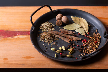 Wall Mural - Food concept ingredients of Masala curry spice in vintage iron tray on wood background with copy space