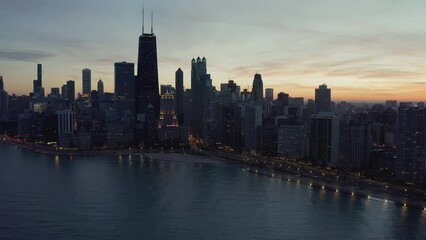 Poster - Flying backwards above Chicago downtown and Lake Michigan at dusk. Busy road by the beach and city lights