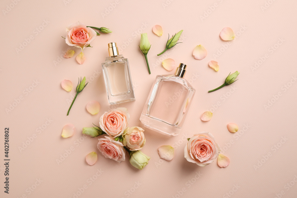 Flat lay composition with different perfume bottles and fresh flowers on beige background - obrazy, fototapety, plakaty 