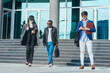 © qunica.com - Three corporate people standing in front of the office building and discussing business