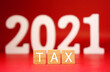 © kittinit - Tax 2021 word on red background - Business and Planning cost investment 2021 concept - Calculate Reduce Taxes or Taxes back and return