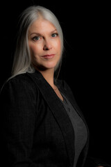 Wall Mural - Image of a beautiful mature blond woman in the studio. Studio image with a black background.