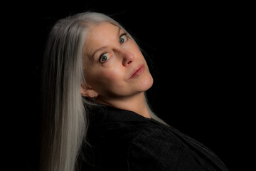 Wall Mural - Image of a beautiful mature blond woman in the studio. Studio image with a black background.