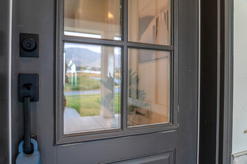 Wall Mural - Close up of gray front door of home with glass panels black handle and keyhole