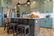 Kitchen island with stools against cabinets refrigerator and cooktop background