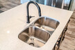 © Jason - Black curved faucet over stainless steel undermount sink with double basins