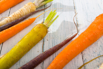 Wall Mural - carrot variations in a row, on white wood table