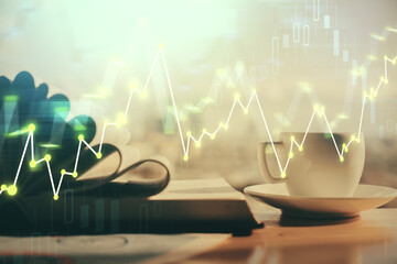 Double exposure of financial chart drawing and desktop with coffee and items on table background. Concept of forex market trading