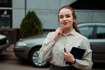 Wall Mural - Young woman ginger redhead girl hold tablet digital pc wireless and pen. Pretty smiling confident lady, daily distance remote work. Small business owner standing outside, blur background copy space
