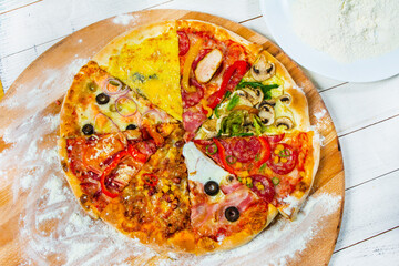 Different slices of pizza with different toppings on a white background. Cut into slices delicious fresh pizza. Tasty pizza on white.