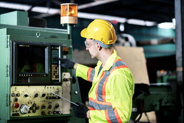 Engineer / worker man caucasian happy smiling in protective safety jumpsuit uniform with yellow hardhat and using tablet at factory.Metal working industry concept professional engineer manufacturing