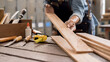© MIND AND I - Carpenter working with equipment on wooden table in carpentry shop. woman works in a carpentry shop.