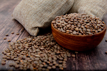 Wall Mural - Organic brown Lentils in a wooden bowl