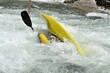 athlete does stunts with canoe on the river for extreme sport