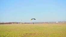 Skydiver With A Parachute Canopy Lands On The Field. Parachute Jumps. Skydiving.