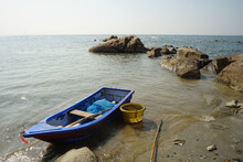 A Small Blue Fishing Boat Moored On The Beach.
