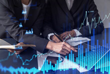 Two Traders Researching Historic Data To Predict Stock Market Behavior. Women In Trading Business Concept. Forex And Financial Hologram Chart Over The Table With The Document.