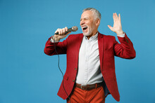 Cheerful Elderly Gray-haired Mustache Bearded Business Man Wearing Red Jacket Suit Standing Sing Song In Microphone Spreading Hands Looking Aside Isolated On Blue Color Background Studio Portrait.