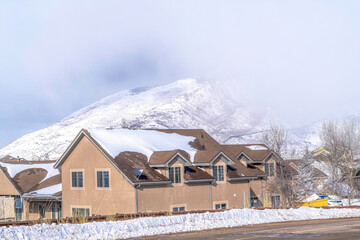 Canvas Print - Beautiful snowy peak viewed from a mountain neighborhood with buildings and road