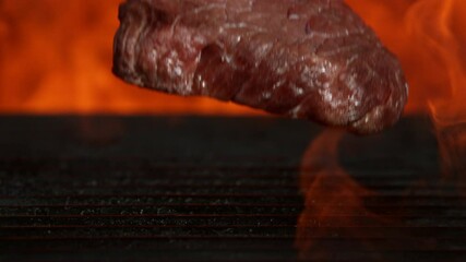 Wall Mural - Super slow motion of falling raw beef steak on grill. Filmed on high speed cinema camera, 1000 fps.