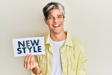 Sticker - Young hispanic man holding new style message on paper looking positive and happy standing and smiling with a confident smile showing teeth