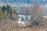 Fototapeta Tulipany - Homemade elevated hunting blind during winter with snow. Selective focus, background blur and foreground blur.
