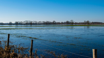 Vendée, France; January 2, 2021: the marshes of blue colors are frozen, winter is here, a superb day with a magnificent sky, not far from Challans.

